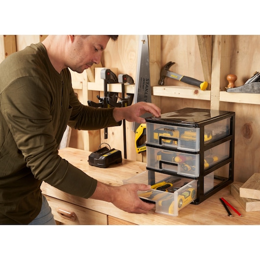 STANLEY STST40712-1 organizer with three transparent drawers on a workbench, storing hand tools.