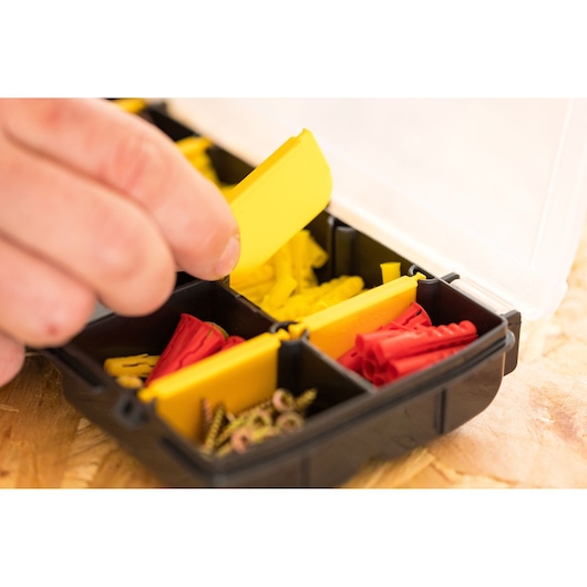 STANLEY STST81679-1 hardware organizer with yellow and red wall plugs and screws, close-up photo.