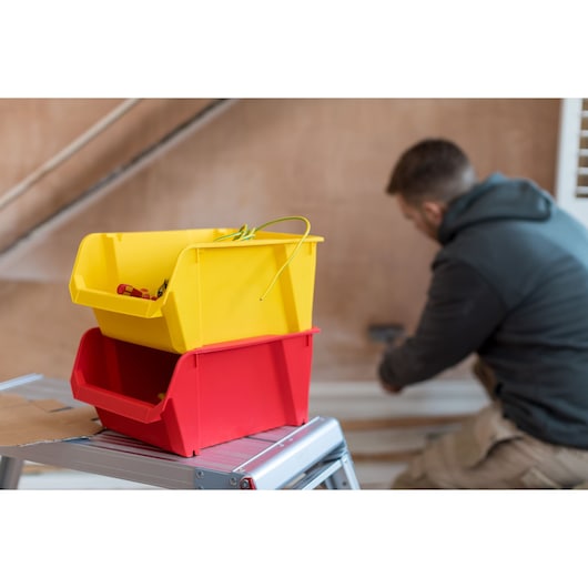 STANLEY STST82742-1 photography of yellow and red storage bins on metal step ladder indoors.