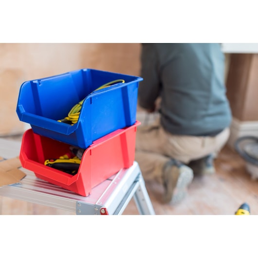 STANLEY STST82743-1 photography of red and blue storage bins on a step ladder, filled with tools and cables.