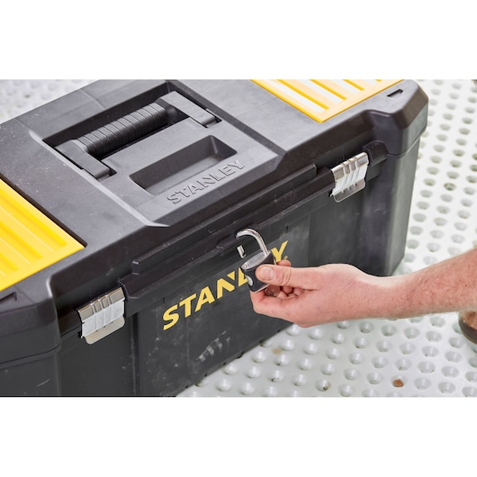 STANLEY STST82976-1 toolbox front angle, black and yellow with padlock being unlocked by hand.