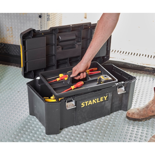STANLEY STST82976-1 tool box with open lid, tray holding screwdrivers and tape measure on industrial floor.