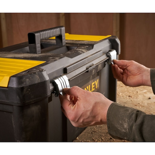 STANLEY STST82976-1 tool box with yellow lid and black handle being latched shut, front angle.