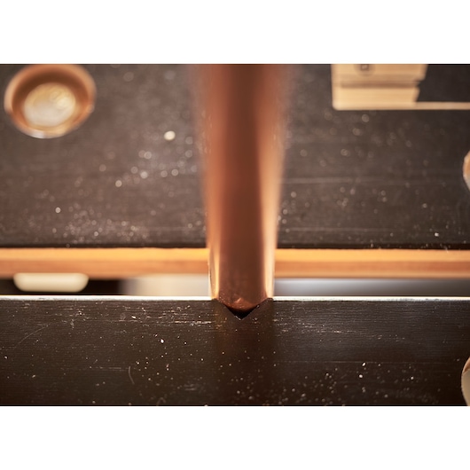 STANLEY STST83400-1 photography of a copper pipe fitted into a black metal workbench groove.