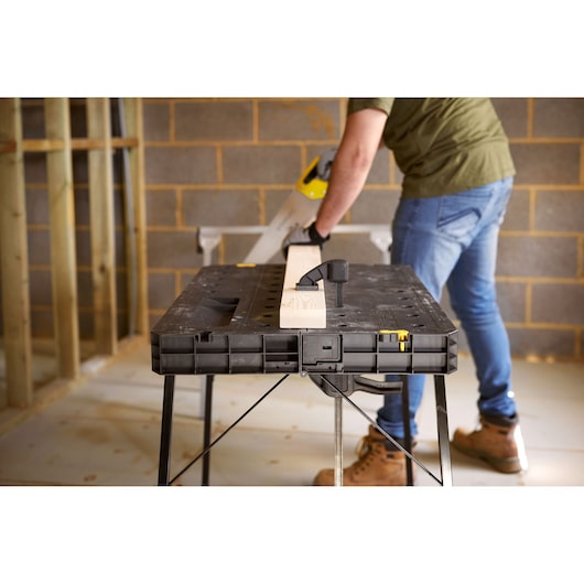 STANLEY STST83492-1 workbench table in use, black plastic with foldable legs, photography from front angle.